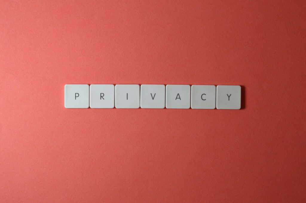Close-up of letter tiles spelling PRIVACY on a red background, symbolizing data protection.